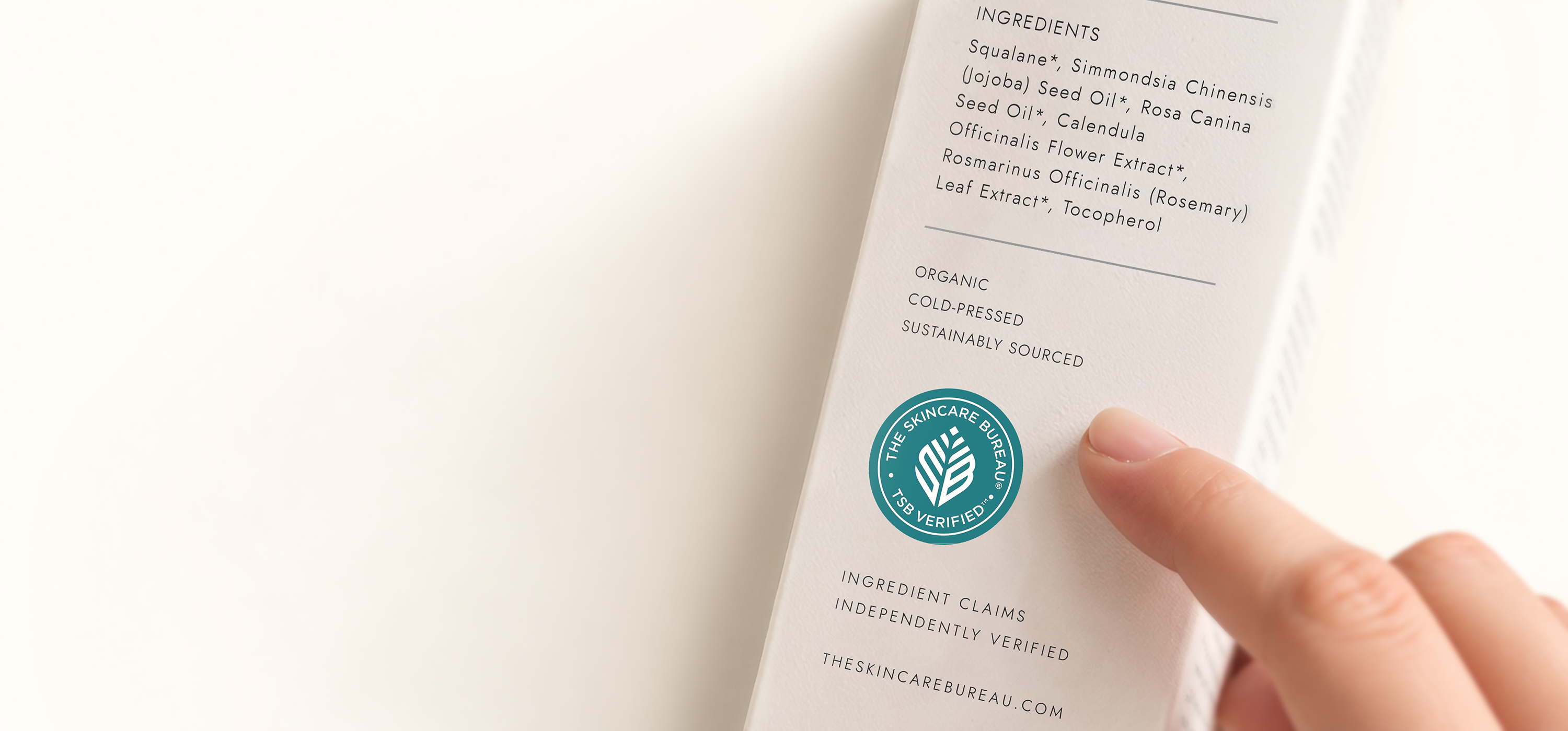 A hand pointing to the teal TSB Verified™ seal beneath ingredient and sourcing claims on a skincare carton